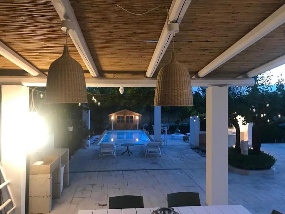 un patio avec une piscine et deux suspensions dans l'établissement Dolce Villa, à Francavilla Fontana
