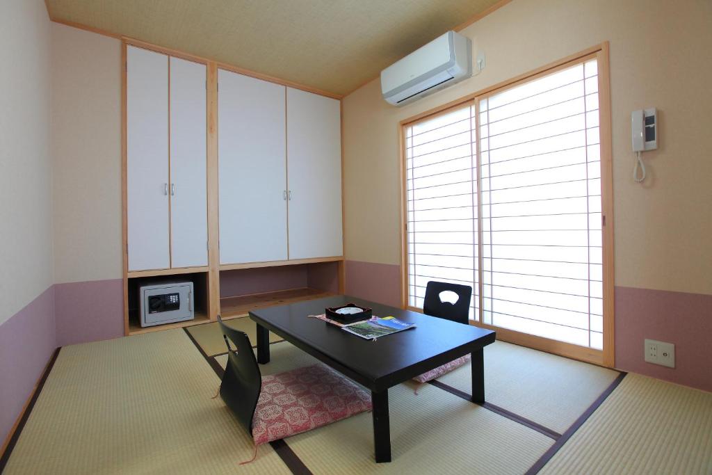 un salon avec une table noire et une chaise dans l'établissement 和みの宿 弓ヶ浜いち番館, à Minamiizu 19 autres photos