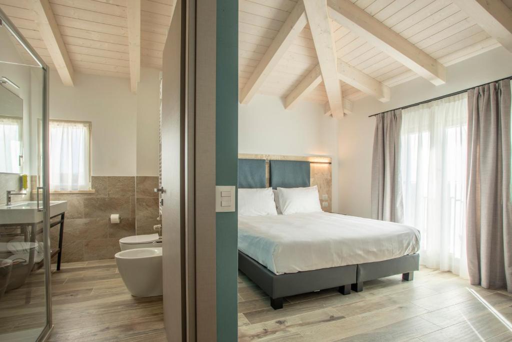 - une chambre avec un lit et une salle de bains dans l'établissement Riva Toscana Golf Resort & SPA, à Follonica