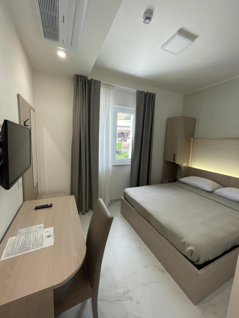 une chambre avec un lit, un bureau et une table dans l'établissement Hotel Diadema, à Diamante