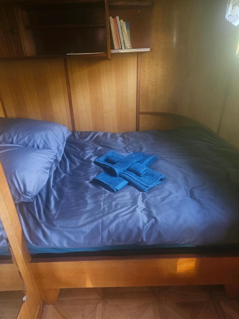 un lit avec deux serviettes bleues dessus dans l'établissement peniche logement, à Creil