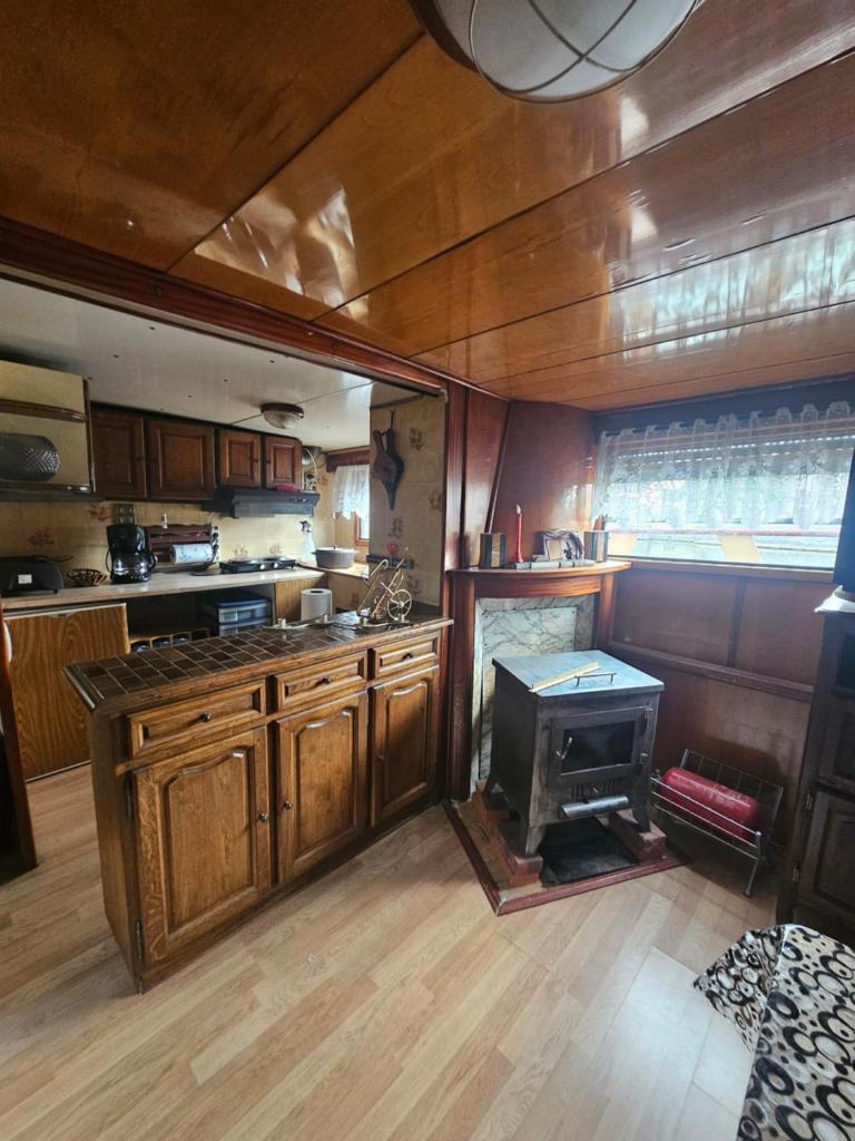 - une cuisine avec des placards en bois et une cuisinière dans l'établissement peniche logement, à Creil 4 autres photos