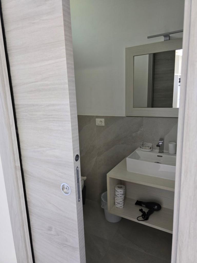 une salle de bain avec un lavabo et un miroir dans l'établissement Hotel la Praia, à Zambrone