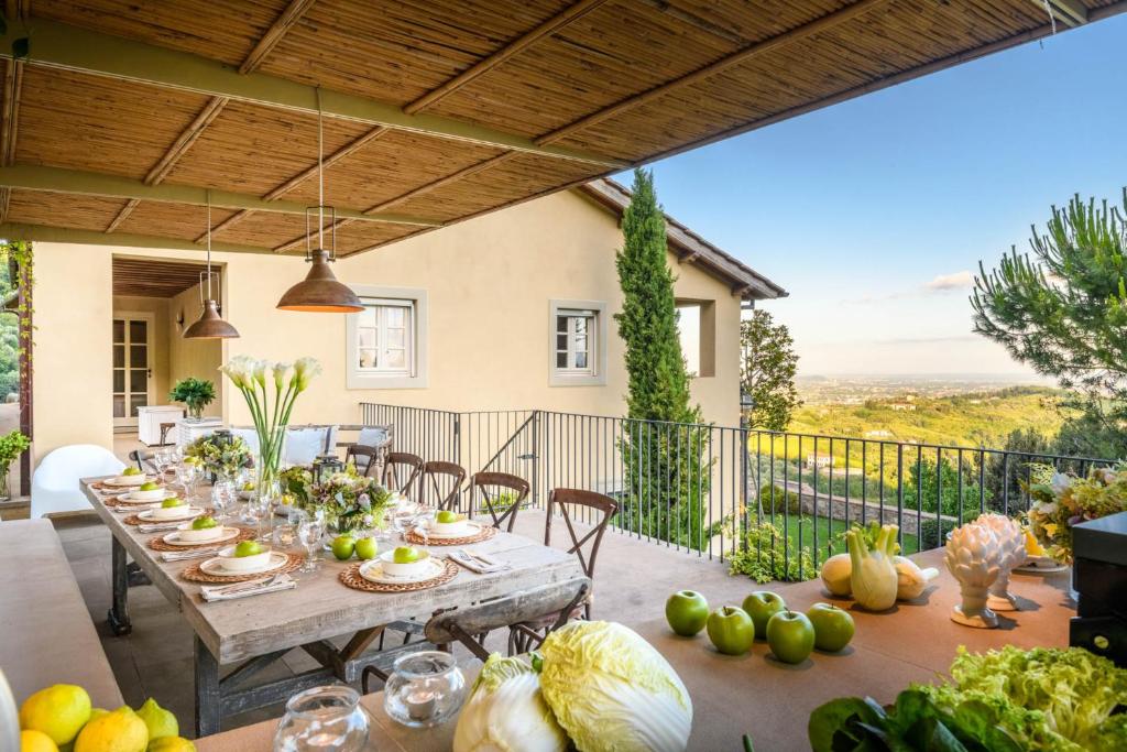 une table avec des légumes sur une terrasse avec vue dans l'établissement Villa Sunset, Luxury Farmhouse with Infinity Pool, à Lucques
