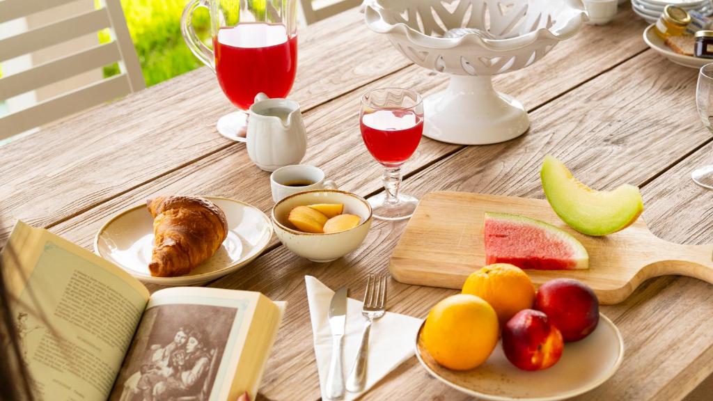 une table en bois avec des assiettes de nourriture et de boissons dans l'établissement Masseria Macchiaforte, à Gallipoli 130 autres photos