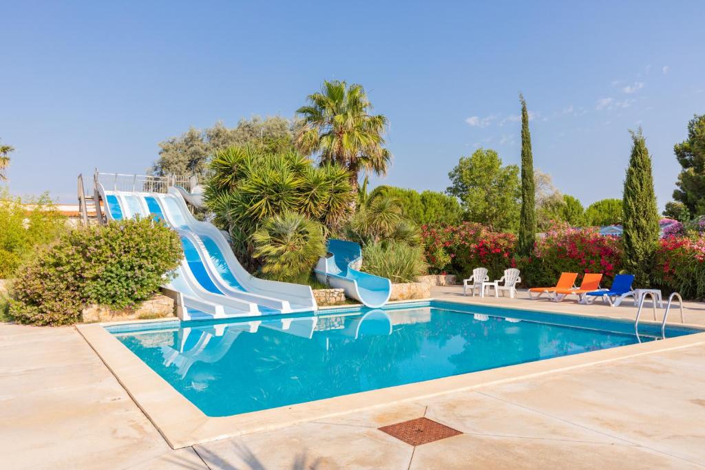 - une piscine avec toboggan dans un complexe dans l'établissement Mobil Home XXL 4 chambres - Camping Les Tropiques, à Torreilles