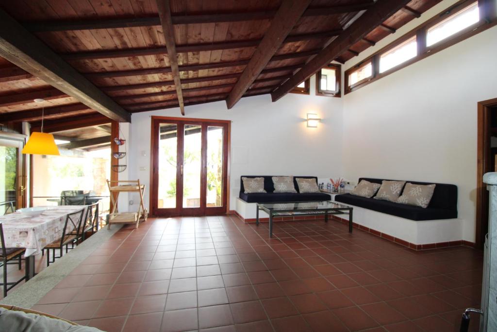 un salon avec un canapé et une table dans l'établissement Domus Cristianae Villa Exclusive Pool Sea View, à Nuragheddu