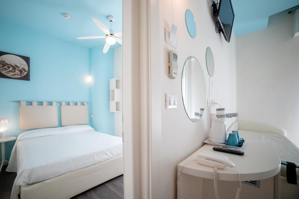 une petite chambre avec un lit et un miroir dans l'établissement Hotel Casablanca, à Rimini 61 autres photos