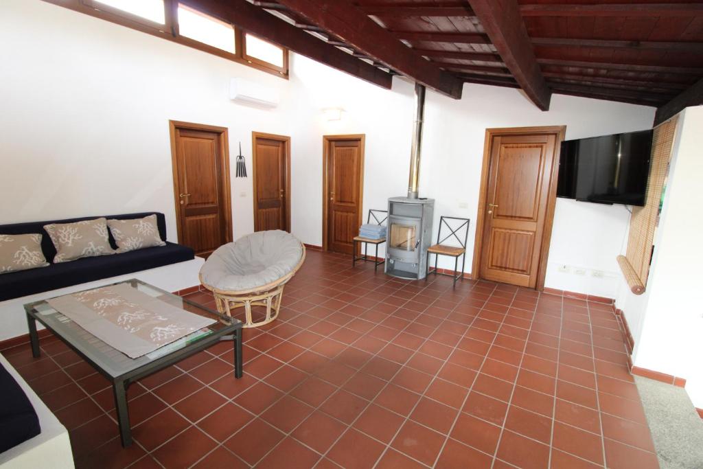 un salon avec un canapé et une télévision dans l'établissement Domus Cristianae Villa Exclusive Pool Sea View, à Nuragheddu