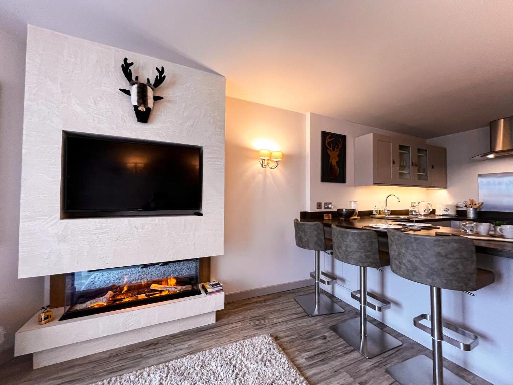 un salon avec une cheminée avec une télévision au-dessus dans l'établissement Appartement de Standing - Ski au pied, à Val Thorens