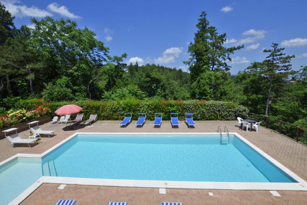 une piscine avec chaises et parasols dans l'établissement Villa Francesca - Happy Rentals, à Anghiari