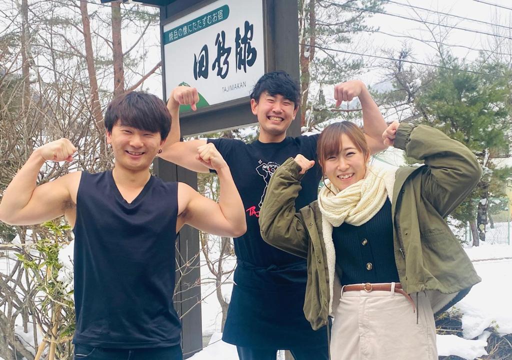 un groupe de trois personnes posant pour une photo dans l'établissement 筋肉と自然と遊ぶ宿 田島館, à Takayama