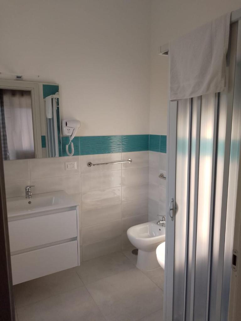 une salle de bain avec des toilettes blanches et un lavabo dans l'établissement Villa3 Cancelli Guesthouse B&B via del Mare Formia, à Formia