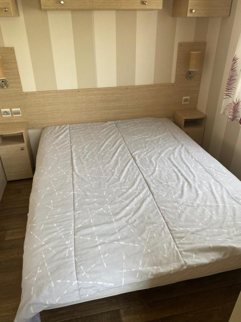 Ce lit se trouve dans un dortoir doté d'un matelas blanc. dans l'établissement Mobil Home dans le camping 4 étoiles le Montourey, à Fréjus