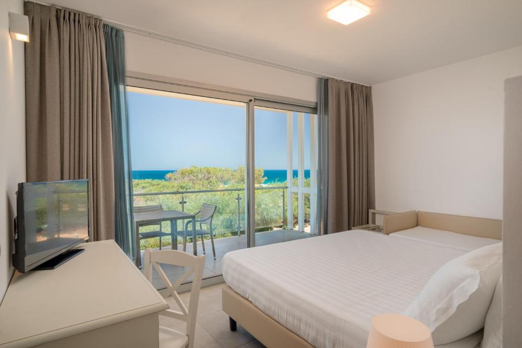 une chambre d'hôtel avec un lit et une vue sur l'océan dans l'établissement Bellevue Sardinia Resort Affiliated by Meliá, à Valledoria