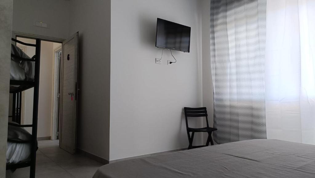 une chambre avec un lit et une télévision sur un mur dans l'établissement Villa3 Cancelli Guesthouse B&B via del Mare Formia, à Formia