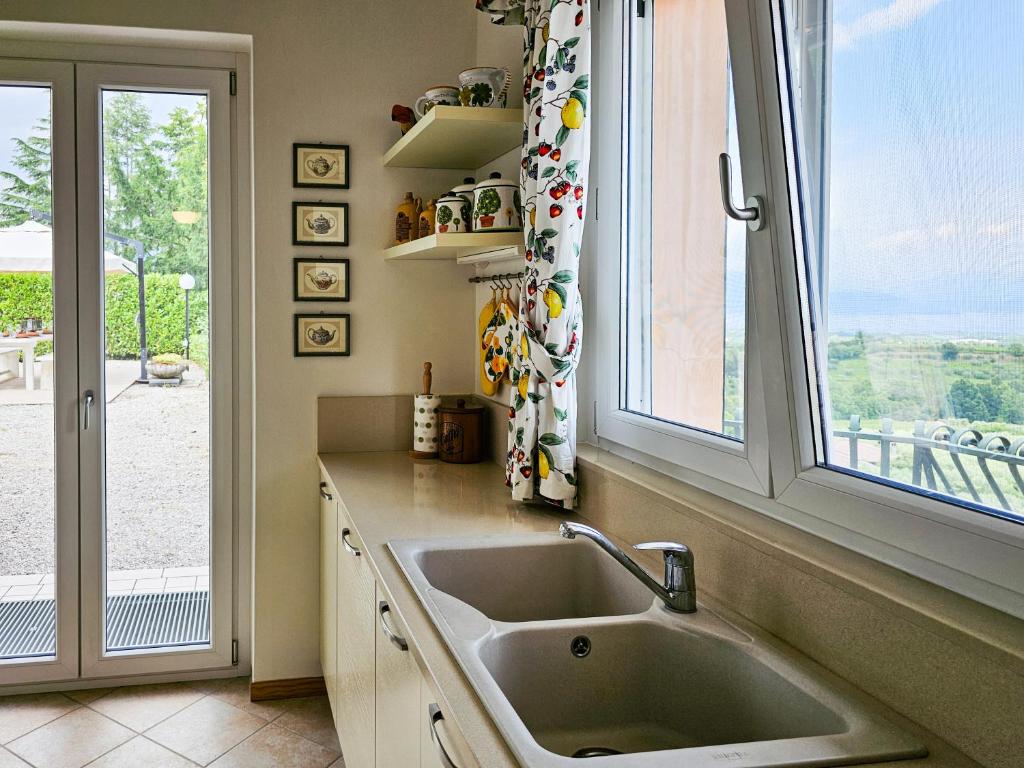 une cuisine avec un évier et une fenêtre dans l'établissement Villa Venti, à Polpenazze del Garda