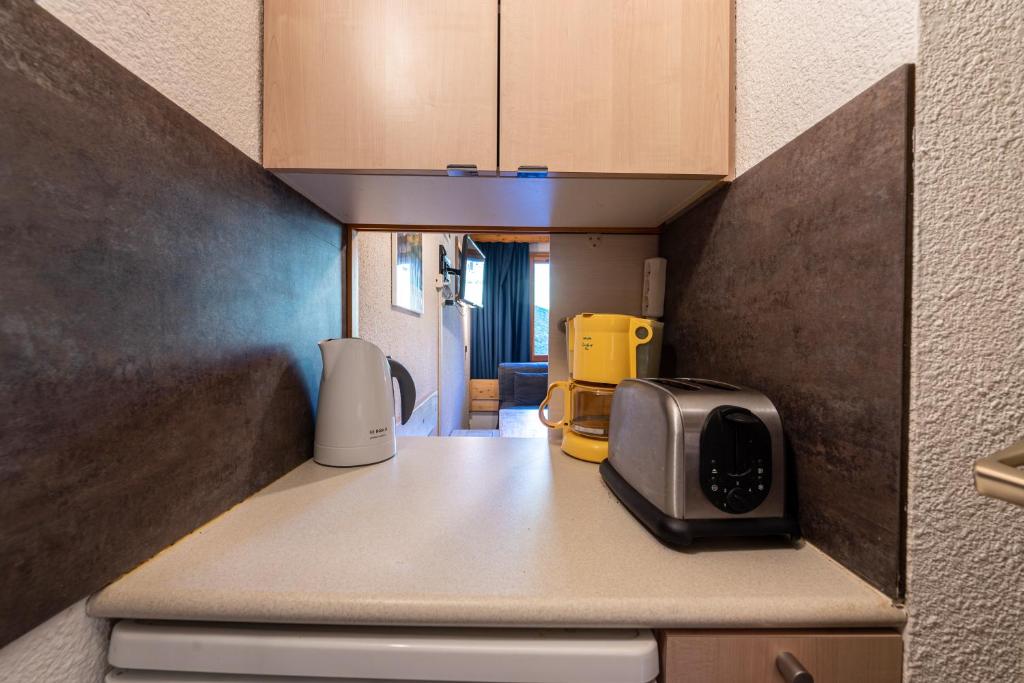 une cuisine avec un grille-pain et un micro-ondes sur un comptoir dans l'établissement Appartement 4p, à Les Allues