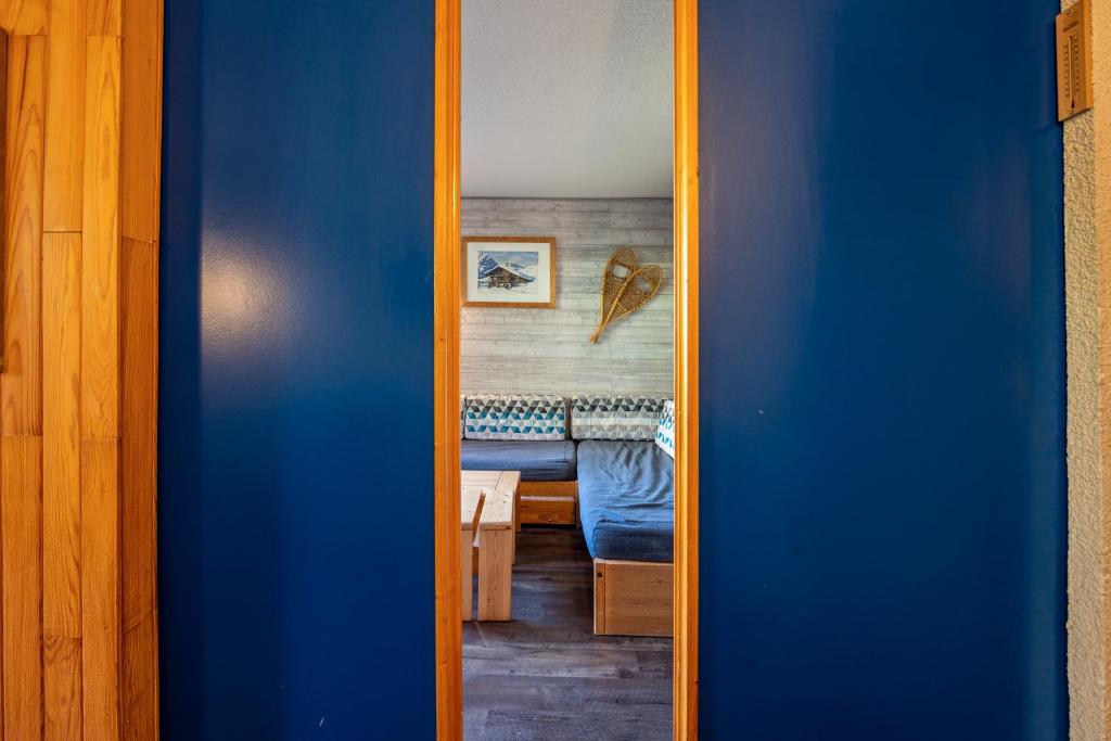 une porte bleue menant à une pièce avec une table dans l'établissement Appartement 4p, à Les Allues