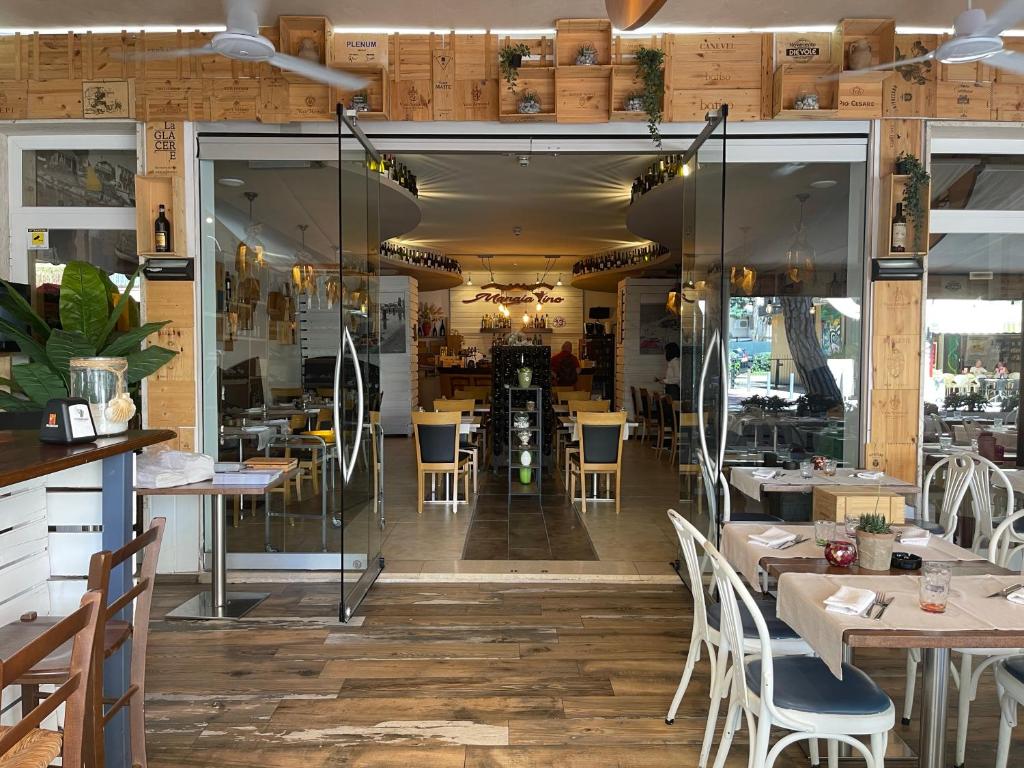 un restaurant avec du parquet, des tables et des chaises dans l'établissement Acapulco Beach, à Lido di Jesolo