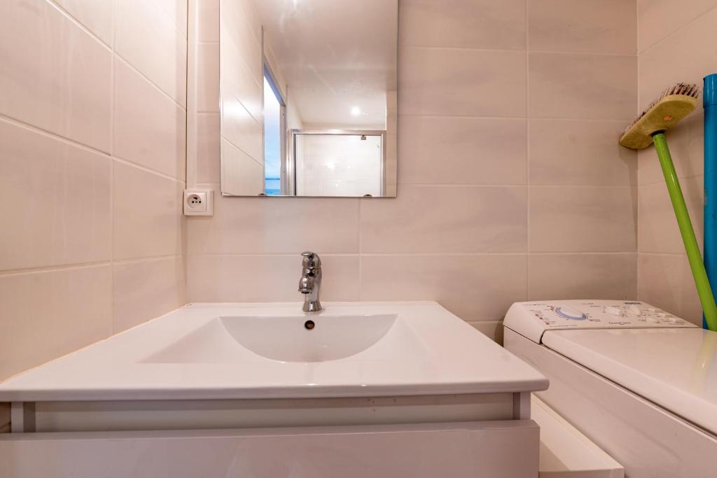 une salle de bain avec un lavabo, une baignoire et un miroir dans l'établissement Le Villaret, aux Menuires