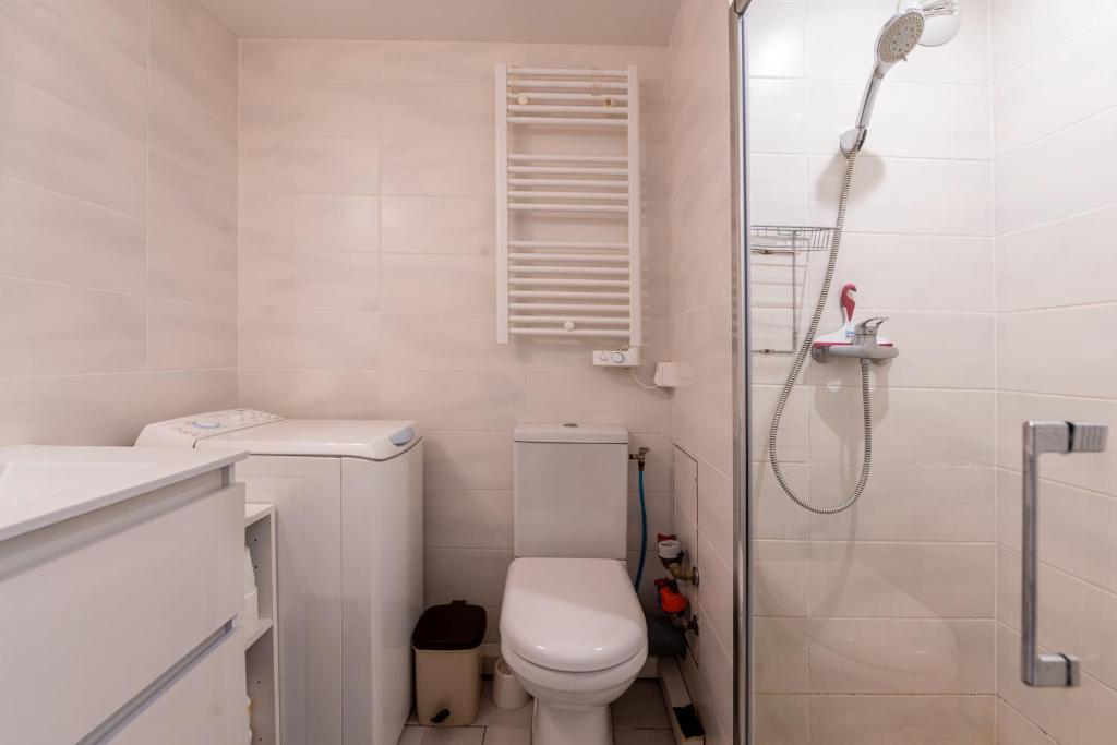 une salle de bain blanche avec toilettes et douche dans l'établissement Le Villaret, aux Menuires 12 autres photos
