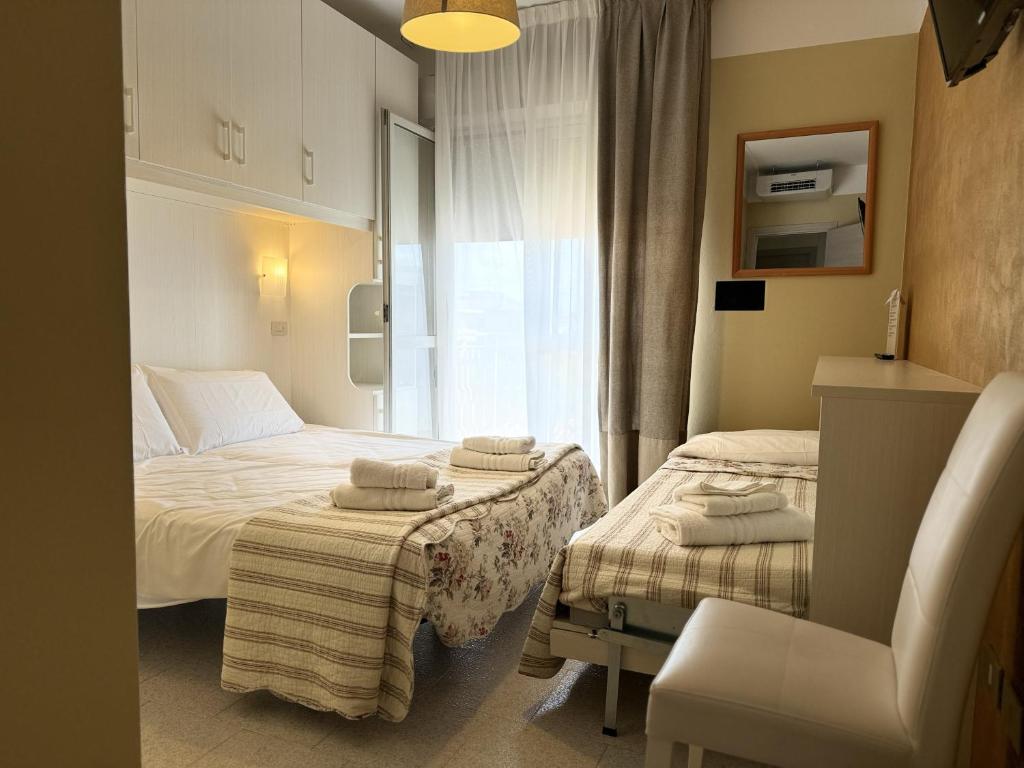 une chambre d'hôtel avec deux lits et une fenêtre dans l'établissement Acapulco Beach, à Lido di Jesolo