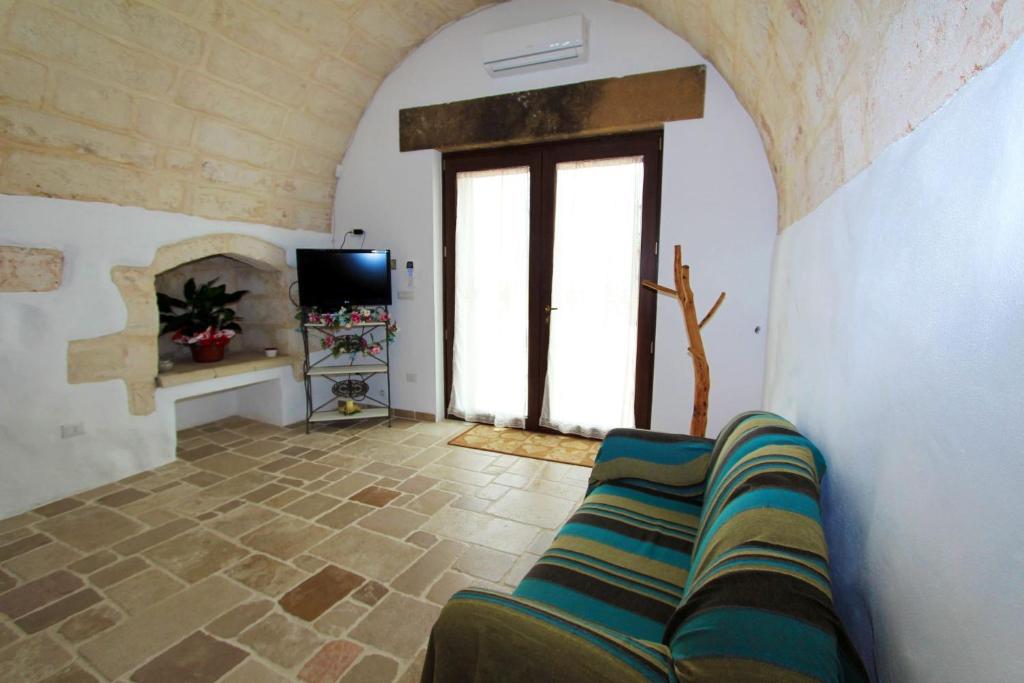 un salon avec un canapé et une télévision dans l'établissement Villa Luce, à Leuca