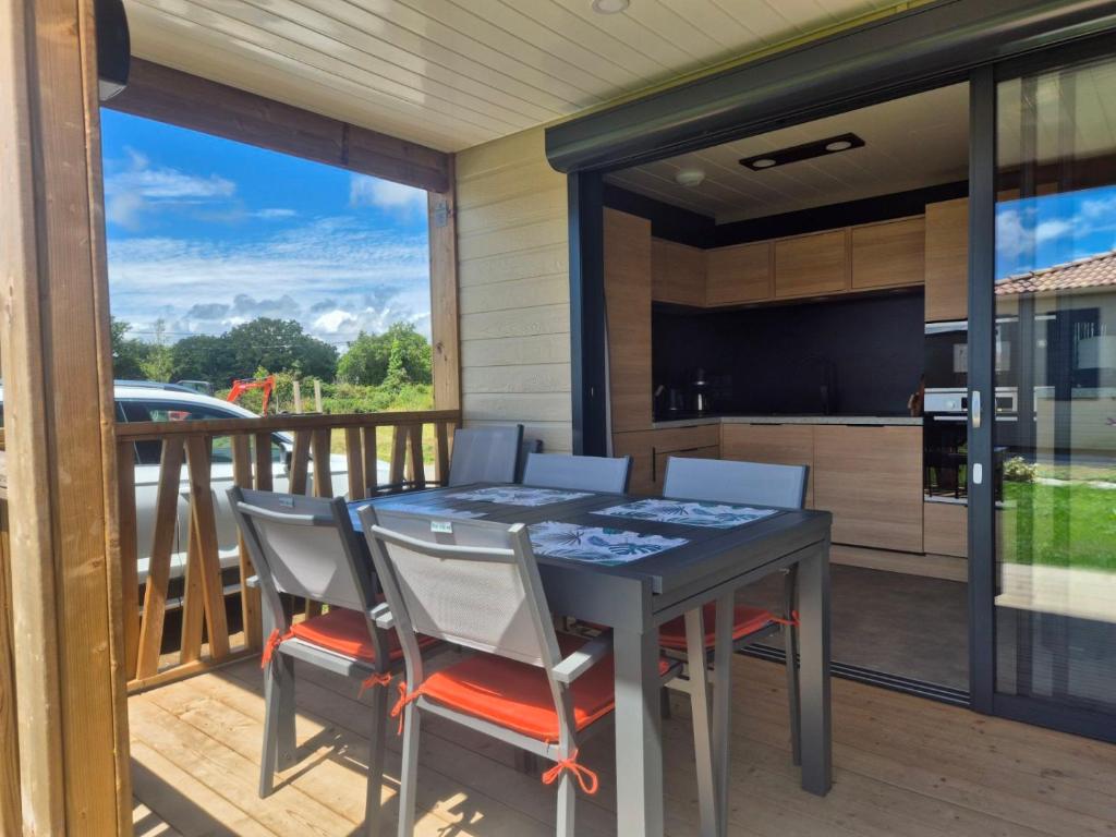 un patio avec une table et des chaises sur une terrasse dans l'établissement Chalet dans domaine avec piscine, à Marzan