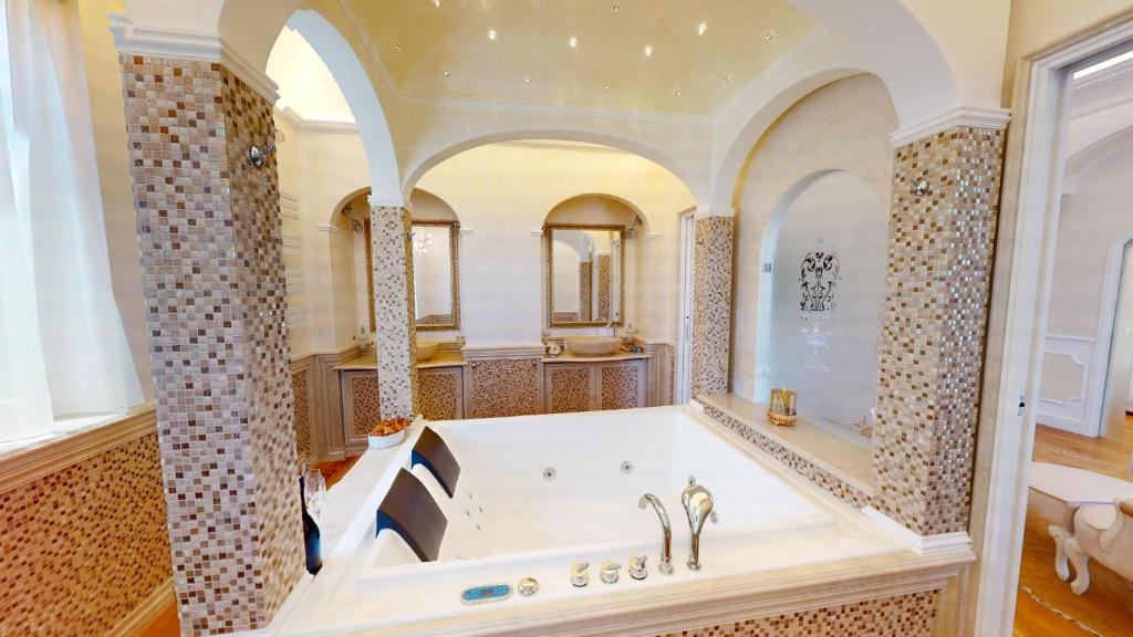 une grande salle de bain avec une baignoire et un grand miroir dans l'établissement Villa Diamante -BGL, à Salò