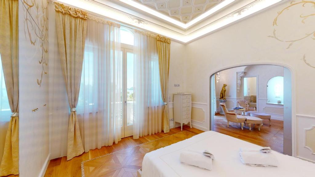 Cette chambre blanche dispose d'un miroir et d'une table. dans l'établissement Villa Diamante -BGL, à Salò 49 autres photos