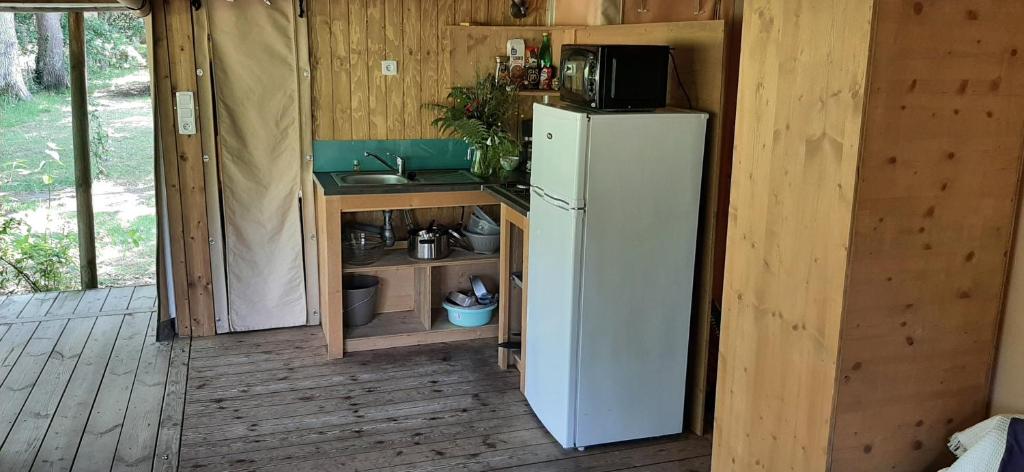 une petite cuisine avec un réfrigérateur et un évier dans l'établissement eco lodge 4 etoiles cotton prenium, à Vendays-Montalivet 13 autres photos