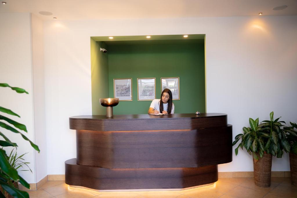 une femme debout à la réception d'un salon dans l'établissement Hotel Garden, à Praia a Mare