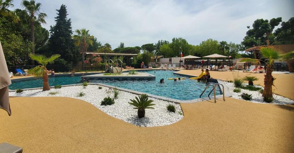 une piscine dans un complexe hôtelier avec des gens dedans dans l'établissement Mobilhome La Marine, au Grau-du-Roi