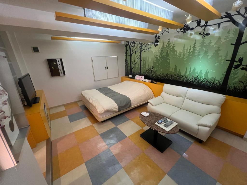 une chambre avec un lit et un canapé dans une pièce dans l'établissement T's Resort HAMAMATSU, à Hamamatsu