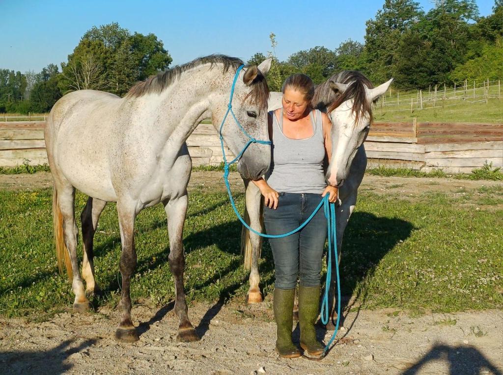 une femme debout à côté d'un cheval blanc dans l'établissement Glamping zelt auf Reiterhof, à Montaigu-de-Quercy