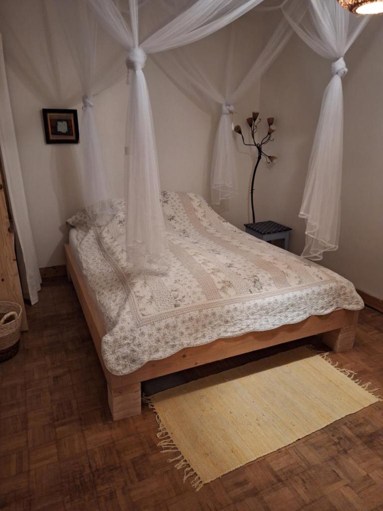 une chambre avec un lit à baldaquin dans l'établissement Glamping zelt auf Reiterhof, à Montaigu-de-Quercy