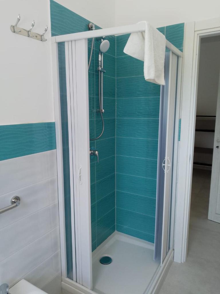 La salle de bains est pourvue d'une douche et de carrelage bleu. dans l'établissement Gianola Residence Monolocali Formia, à Formia