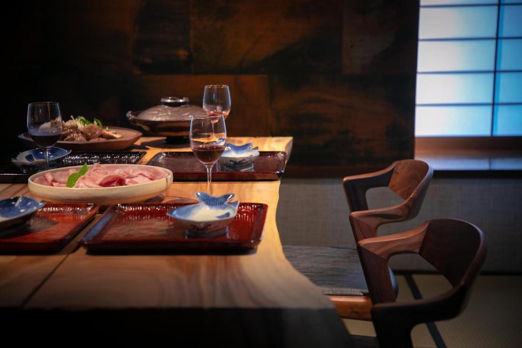 - une table avec des verres de vin et de la nourriture dans l'établissement Yufuin Kaze no Mori, à Yufu