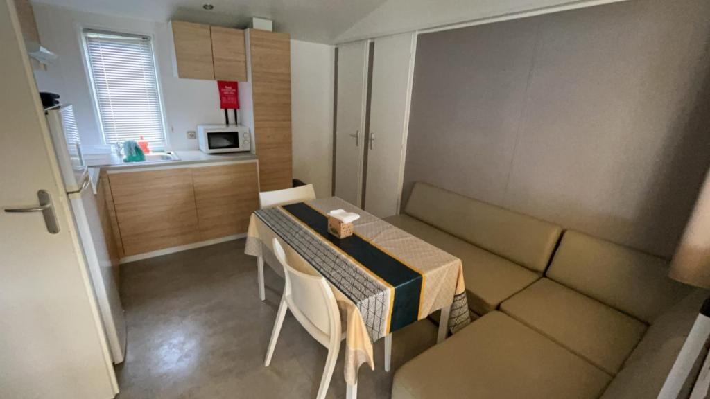 une petite pièce avec une table et une cuisine dans l'établissement Mobil-home confort 6 personnes, à Parentis-en-Born