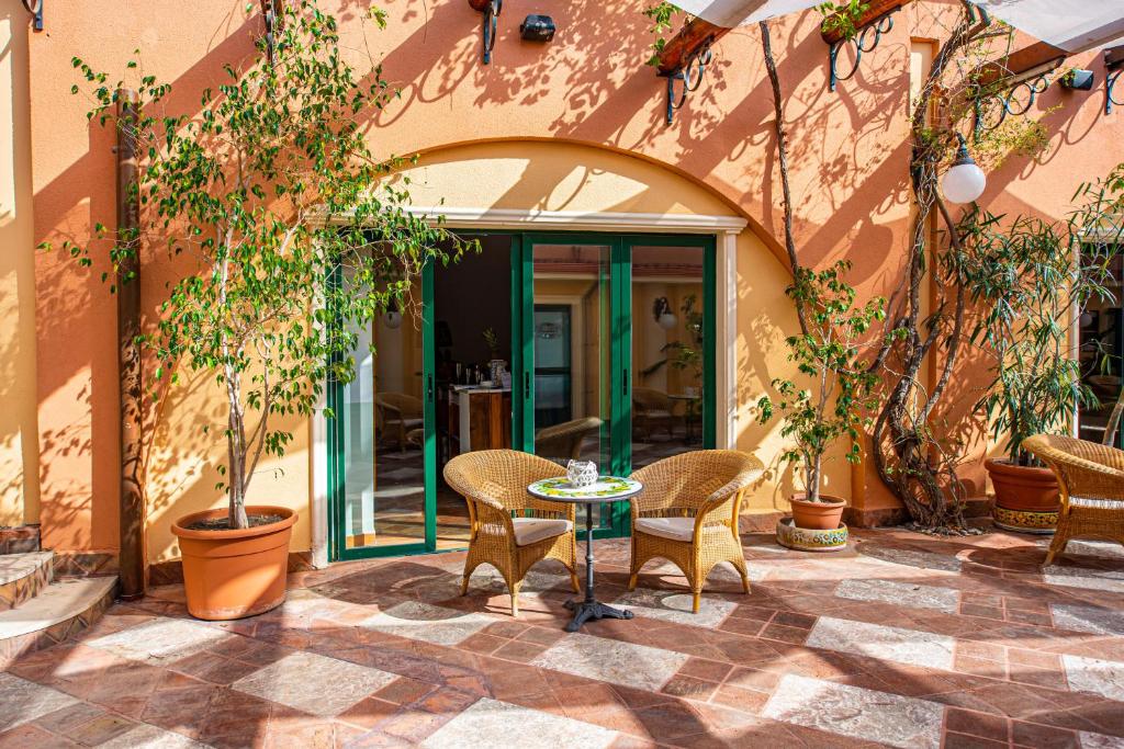 un patio avec une table et des chaises devant un bâtiment dans l'établissement Baia Taormina - CDSHotels, à Forza dʼAgro