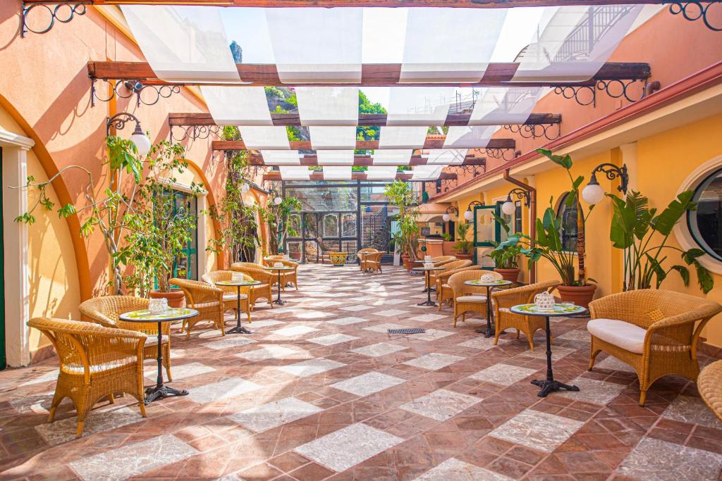 un restaurant avec des tables et des chaises et un plafond dans l'établissement Baia Taormina - CDSHotels, à Forza dʼAgro