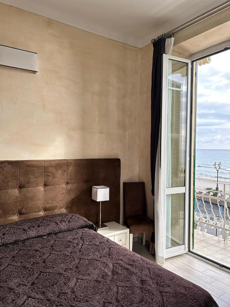 une chambre avec un lit et une vue sur l'océan dans l'établissement Hotel Villa Igea, à Alassio