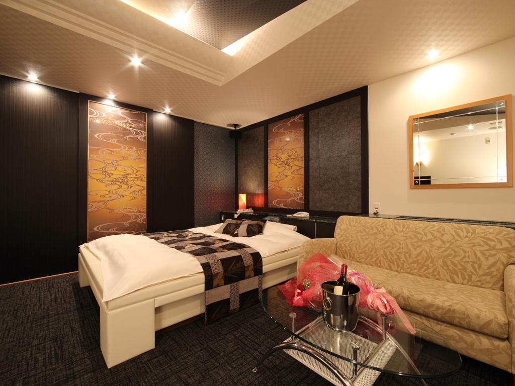 une chambre d'hôtel avec un lit et un canapé dans l'établissement Hotel La Siesta (Adult Only), à Kyoto 6 autres photos