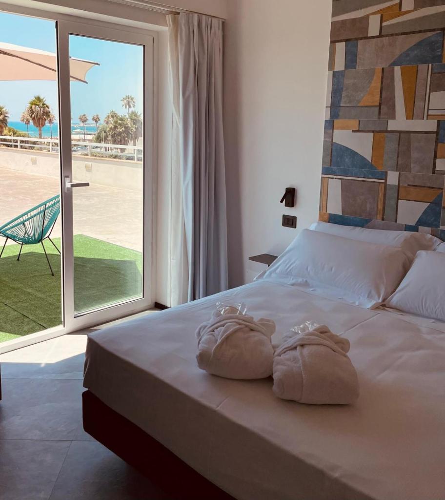 une chambre avec un grand lit avec des serviettes dessus dans l'établissement Andrea Doria Hotel, à Marina di Ragusa