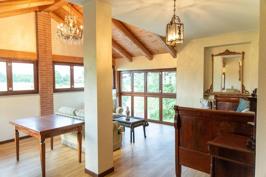 un salon avec une table et un canapé dans l'établissement Villa con vista - piscina e barbecue privati, à San Damiano dʼAsti