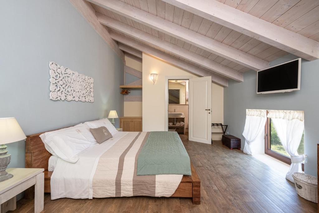 une chambre avec un grand lit et une télévision dans l'établissement Palascìa Wellness Relais, à Otrante