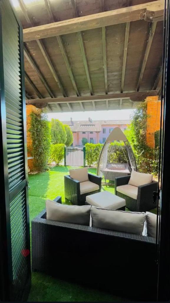 un coin salon extérieur avec des coussins et une table dans l'établissement Villetta faustina, à Albairate