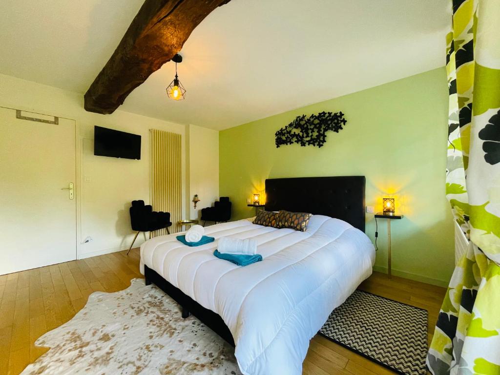 une chambre avec un grand lit blanc dans une pièce dans l'établissement Domaine Jeanne de Laval, à La Bohalle 37 autres photos