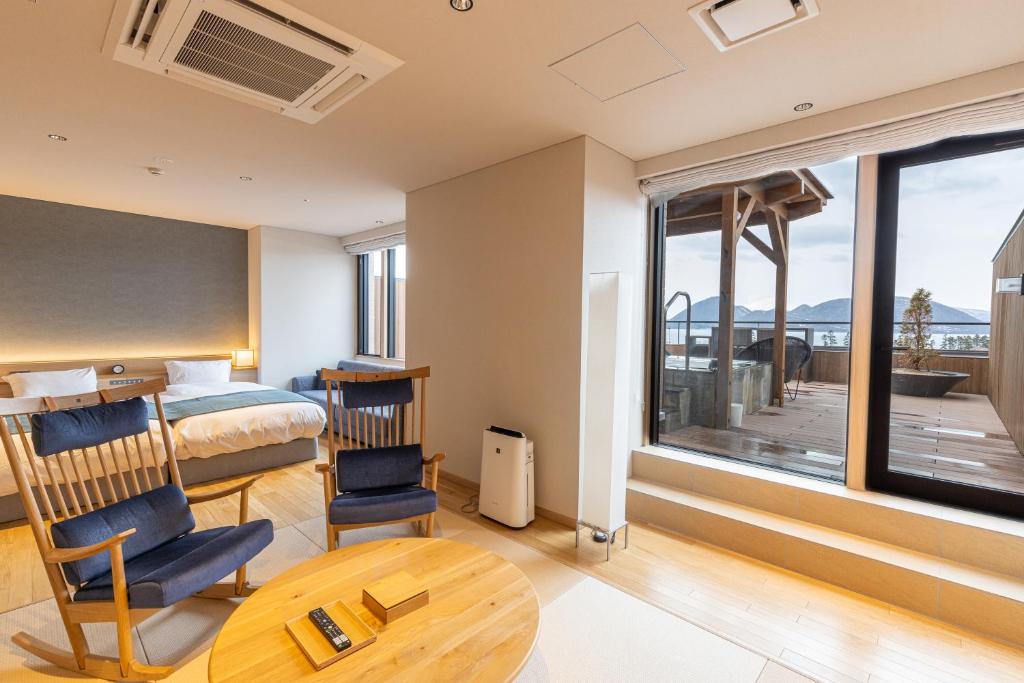 une chambre d'hôtel avec un lit et une grande fenêtre dans l'établissement Lake Toya Tsuruga Resort HIKARINOUTA, à Lac Tōya